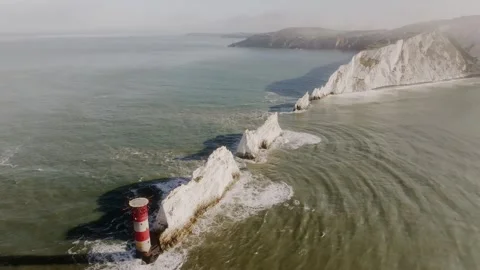 A lighthouse is on a rocky shoreline Stock Footage 297078698