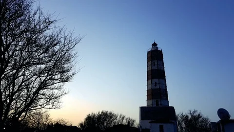 Lighthouse with rotating spotlight during sunset Stock Footage 76826104