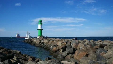 Lighthouse with sailboat and container ship in Rostock port. People. July 2022 Stock Footage 202246358