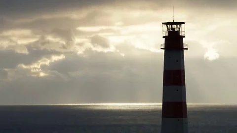 Lighthouse on the sea under stormy clouds at sunset Stock Footage 69218544