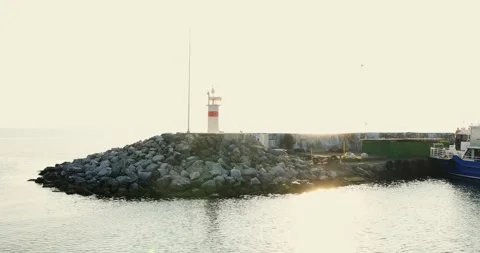 A lighthouse standing gracefully in the middle of the sea on a sunny day Stock Footage 299815056
