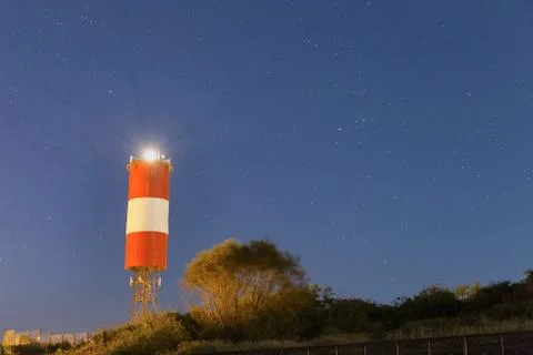 Lighthouse at starry night Stock Photos