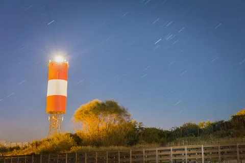 Lighthouse at starry night Stock Photos