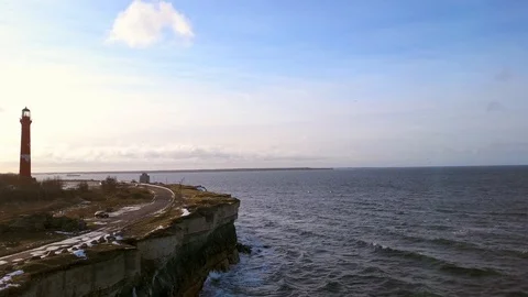 Lighthouse on stone cliffs, surrounded by oceanscape. Aerial reveal shot. Stock Footage 101077404