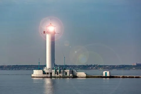 Lighthouse, a stone tower with a bright light for navigation of ships. Stock Photos