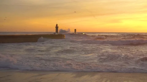 Lighthouse In Stormy Landscape. Big Waves. Sunset.  Stockbeeldmateriaal 229532331