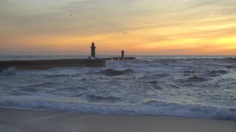 Lighthouse In Stormy Landscape. Big Waves. Sunset. Stockbeeldmateriaal 229533541