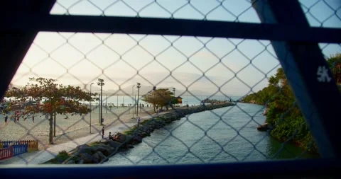 Lighthouse at Sunset in Background and a Bridge Fence in the Foreground Stockbeeldmateriaal 247460398