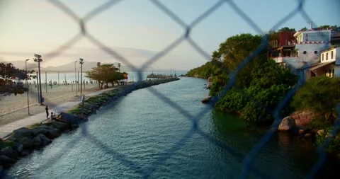 Lighthouse at Sunset in Background and a Bridge Fence in the Foreground Stock Footage 247460502