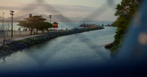 Lighthouse at Sunset in Background and a Bridge Fence in the Foreground Stock Footage 247460722