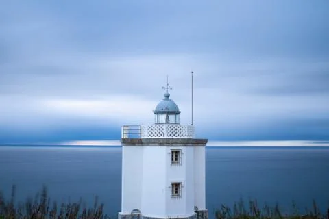 Lighthouse at sunset with clouds in the sky Stock Photos