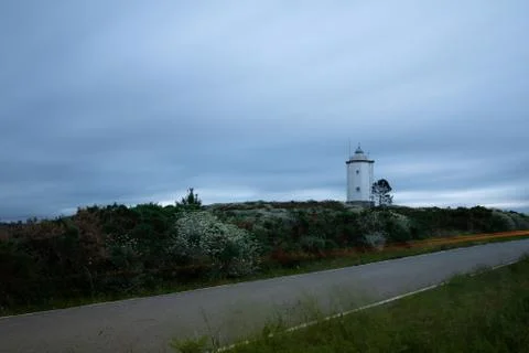 Lighthouse at sunset with silk clouds Stock Photos