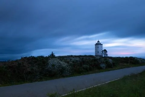 Lighthouse at sunset with silk clouds Stock Photos