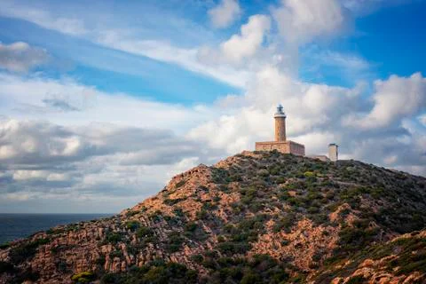 Lighthouse on the top of the Cliff with cloudy sky. - Isola di Pietro , Capo  Stock Photos