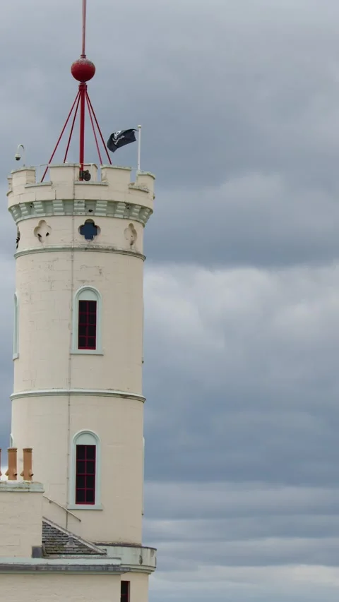 Lighthouse Tower With Flag Waving Under Cloudy Skies Vídeo Stock 317377016