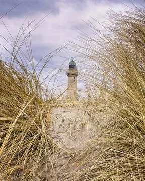 Lighthouse in Warnemunde in the dunes between the dune grass. Stock Photos