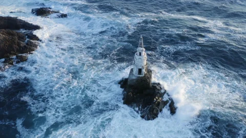 The lighthouse is washed by Ocean waves. Marine sunrise scenery. Aerial view of Vidéo 147979201