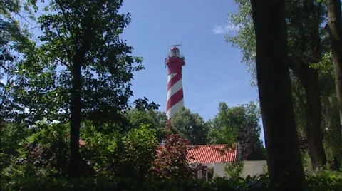 Lighthouse Westerlichttoren towering above forest, The Netherlands + pan 動画素材 40476228