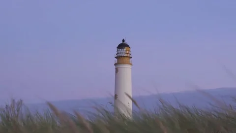 Lighthouse with wheat field blowing in the foreground Stock Footage 167012316