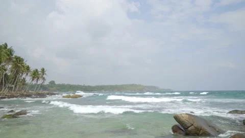 Lighthouse of white stone on the background of palm trees and the sea on the Stock Footage 204806546