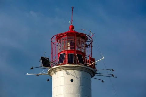 Lighthouse, a white stone tower with a red top for navigation of ships. Stock Photos