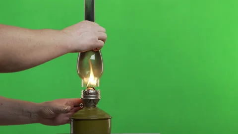 Lighting adjusting an oil lamp flame. Victorian kerosene lantern. Green Screen Stock Footage 148605902