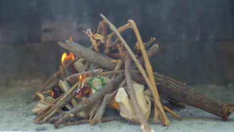 Lighting a bonfire in a barbecue. Smoke between the daylight Vídeos de archivo 328740768