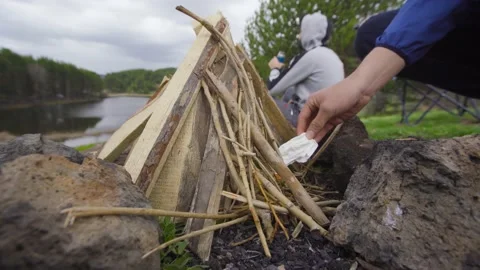 Lighting a campfire with a lighter. 스톡 동영상 198948860