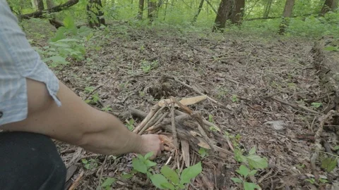 Lighting campfire at a spring forest. Preparing charcoal for sausage roasting Vidéo 118112500