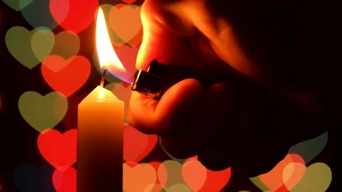 Lighting a candle with a lighter on the background. Valentine's Day Stock Footage 147591161