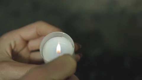 Lighting a candle with a lighter. Close-up shot of a woman's hand Stock Footage 210238481