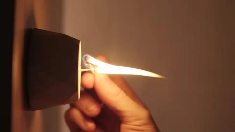 Lighting a candle with a match in the dark. vertical video in slow motion Stock Footage 169177646