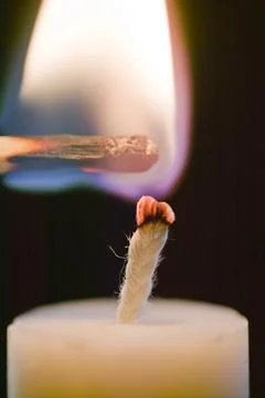Lighting a candle with a match Stock Photos