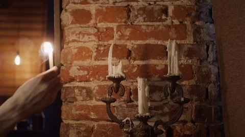 Lighting up candles against brick wall Stock Footage 125033986
