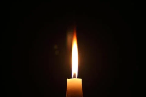 Lighting candles on a black background. Stock Photos
