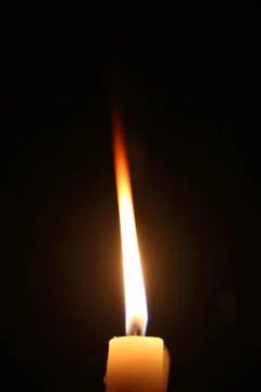 Lighting candles on a black background. Stock Photos