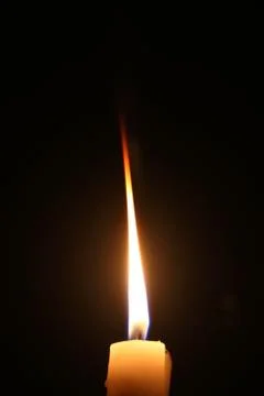 Lighting candles on a black background. 스톡 사진