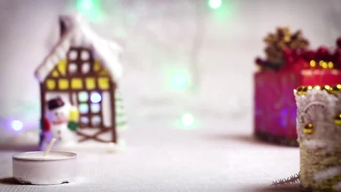 Lighting candles in a New Year's background with a winter house, a Christmas Video stock 82407198