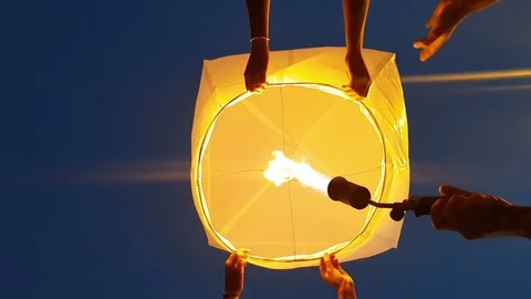 Lighting a Chinese lantern held by a pair of lovers - flying lantern power on Stock-Footage 114710420