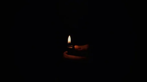 lighting a cigarette with a candle Lighting a cigarette lighter in a warm black background