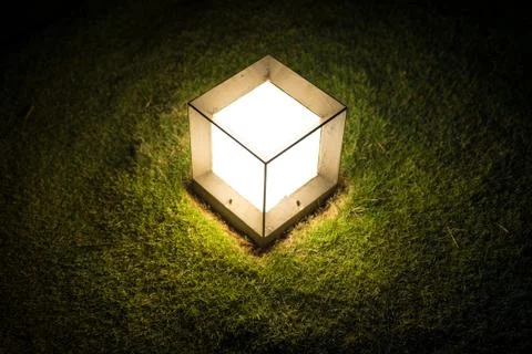 Lighting cube lantern on grass at night. Stock Photos