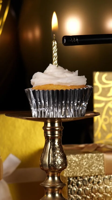 Lighting a Cupcake with Gold Candle and Presents and then blowing out a candle 動画素材 346645184