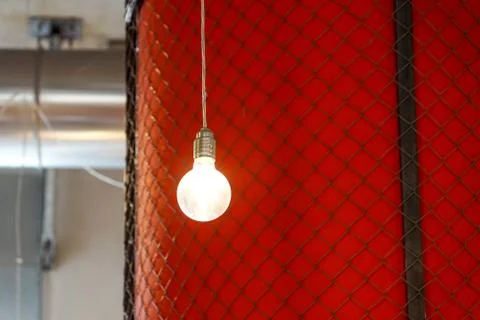 Lighting decor . lighted bulb with red wall as a background Stock Photos