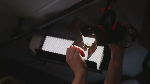 Lighting device. Cinema worker, gaffer turns on the spotlight, turns on the Stock Footage 140450129