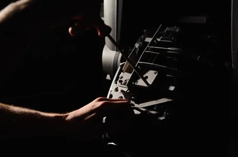 The lighting engineer repairs the light device on stage. Stock Photos