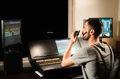 A lighting engineer works with lights technicians control Stock Photos