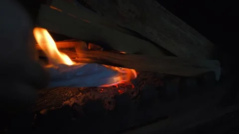 Lighting a fire in a fireplace using paper, close-up Stock Footage 324182924