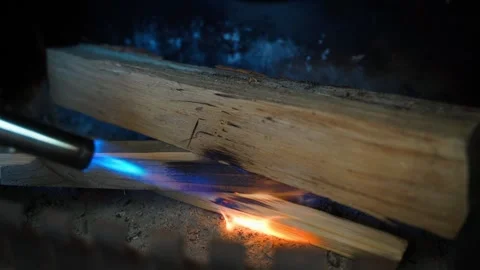 Lighting a fire in a fireplace using a portable gas burner Stock Footage 309115503