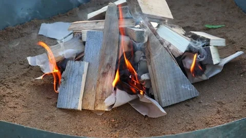 Lighting a fire. Gray paper covered with wooden boards slowly burns. Vidéo 137734058