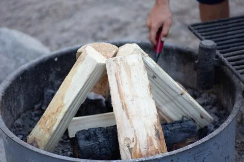 Lighting firewood inside a campfire ring at a campground Stock Photos